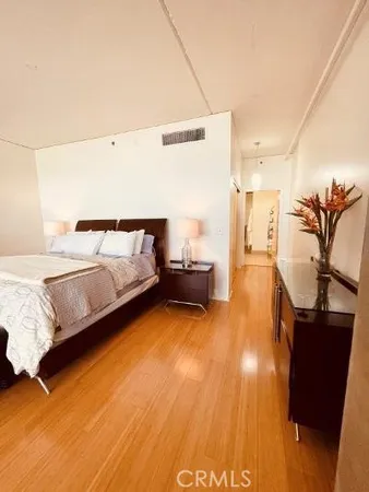 a bedroom with a bed and wooden floor