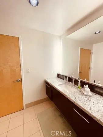 a bathroom with a granite countertop sink and a mirror