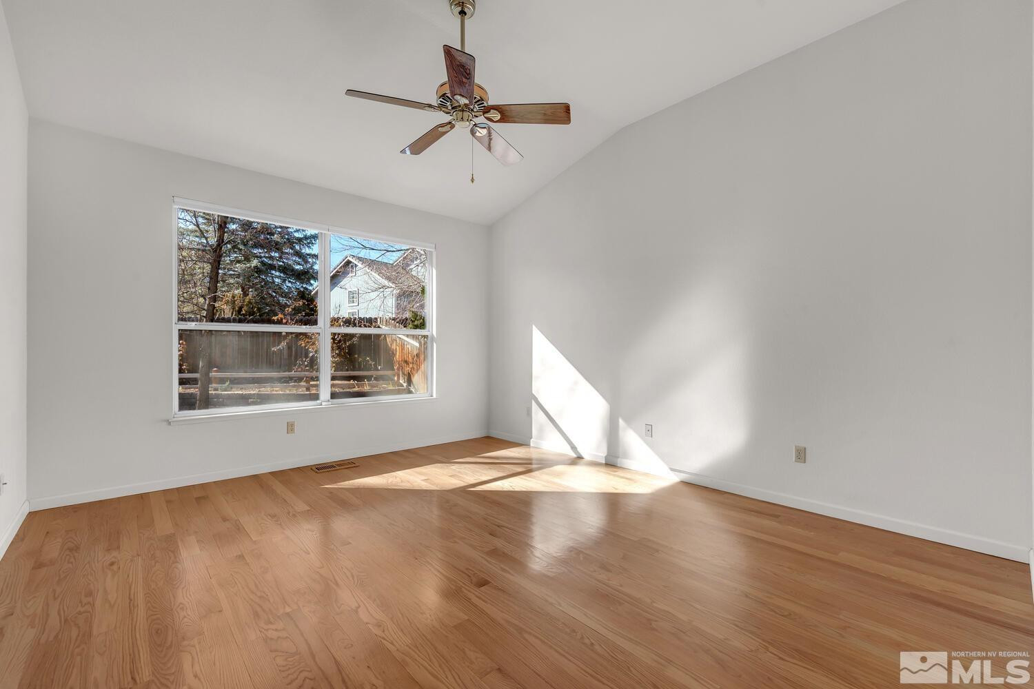 195 Riverbrook Court Reno, NV 89519 - Photo 19 of 40 a view of an empty room with a window and wooden floor
