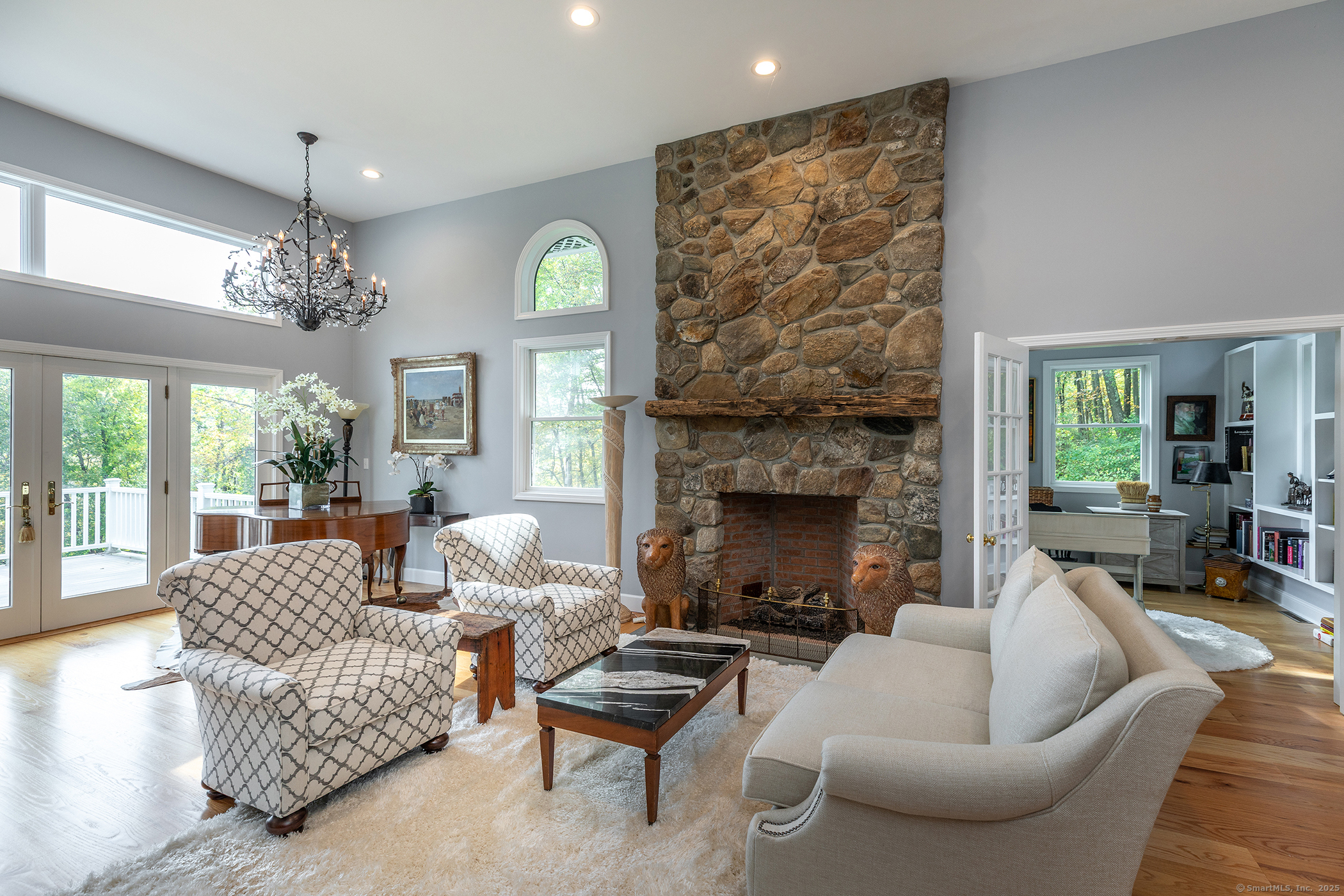 168 Cobble Road Kent, CT 06757 - Photo 24 of 40 a living room with furniture a chandelier and a fireplace