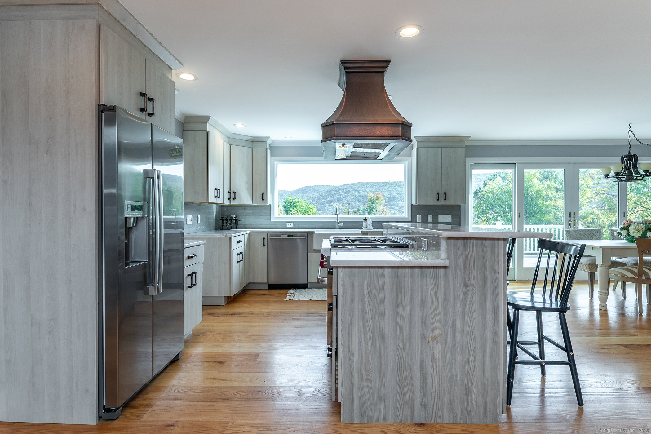 168 Cobble Road Kent, CT 06757 - Photo 6 of 40 a kitchen with stainless steel appliances granite countertop a stove a sink a refrigerator and a dining table with wooden floor