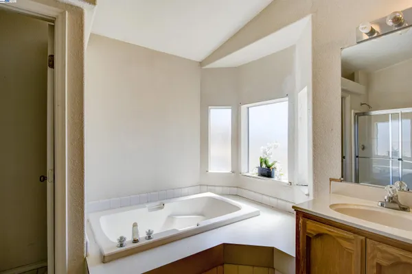 a bathroom with a tub sink and mirror