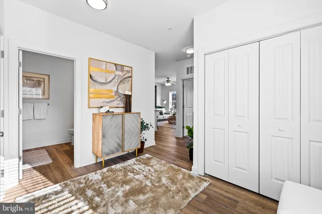 a view of a hallway with wooden floor and cabinet