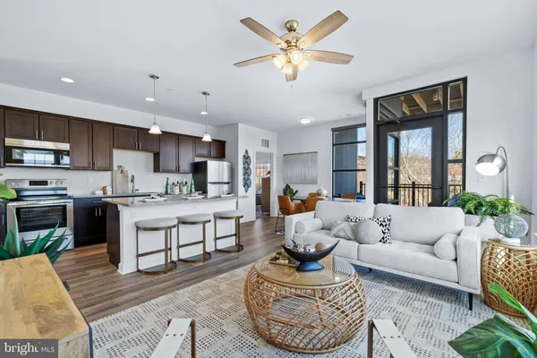 a living room with stainless steel appliances furniture and a view of kitchen