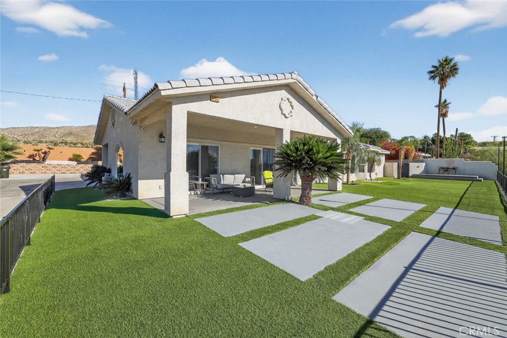 a view of a house with a yard and a patio