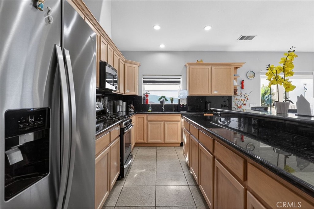 67972 Monterico Road Desert Hot Springs, CA 92240 - Photo 11 of 30 a kitchen with stainless steel appliances granite countertop a stove a sink and a refrigerator