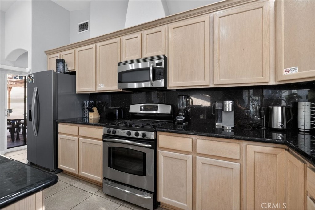 67972 Monterico Road Desert Hot Springs, CA 92240 - Photo 12 of 30 a kitchen with stainless steel appliances granite countertop grey cabinets a refrigerator a stove a sink and dishwasher