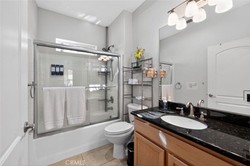 67972 Monterico Road Desert Hot Springs, CA 92240 - Photo 27 of 30 a bathroom with a granite countertop sink a toilet a mirror and shower