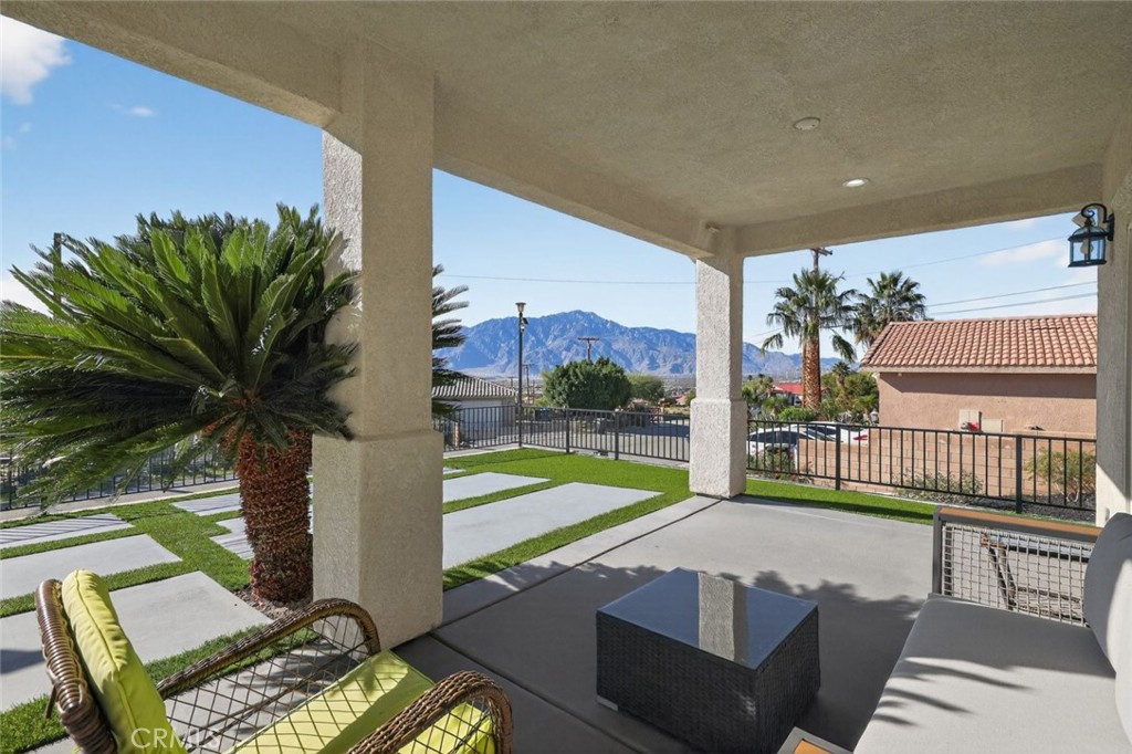67972 Monterico Road Desert Hot Springs, CA 92240 - Photo 4 of 30 a view of a patio with table and chairs potted plants with wooden floor and fence