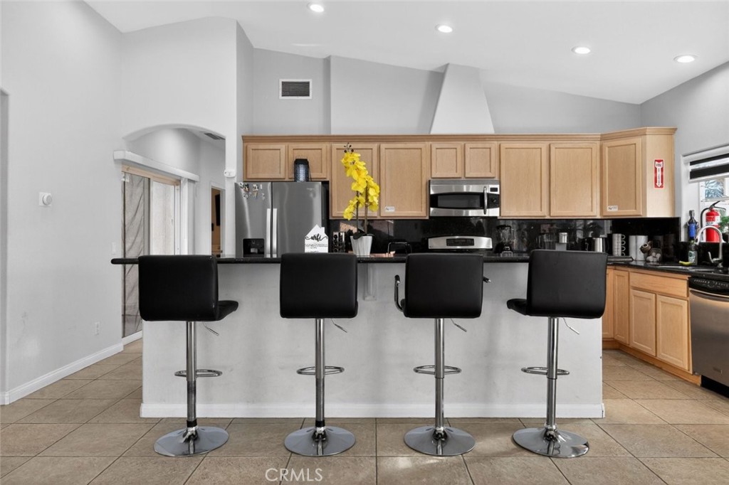 67972 Monterico Road Desert Hot Springs, CA 92240 - Photo 10 of 30 a kitchen with stainless steel appliances kitchen island granite countertop a table and chairs in it