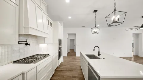 a kitchen with stainless steel appliances a stove a sink and cabinets