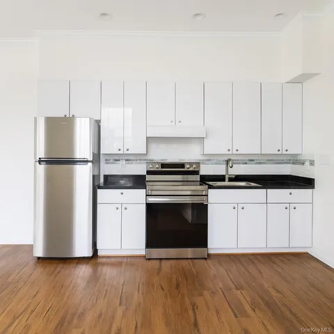a kitchen with granite countertop white cabinets and stainless steel appliances
