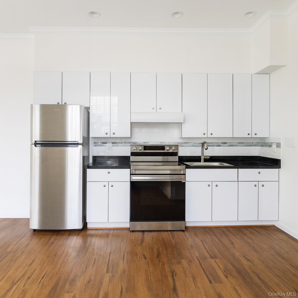 a kitchen with granite countertop white cabinets and stainless steel appliances