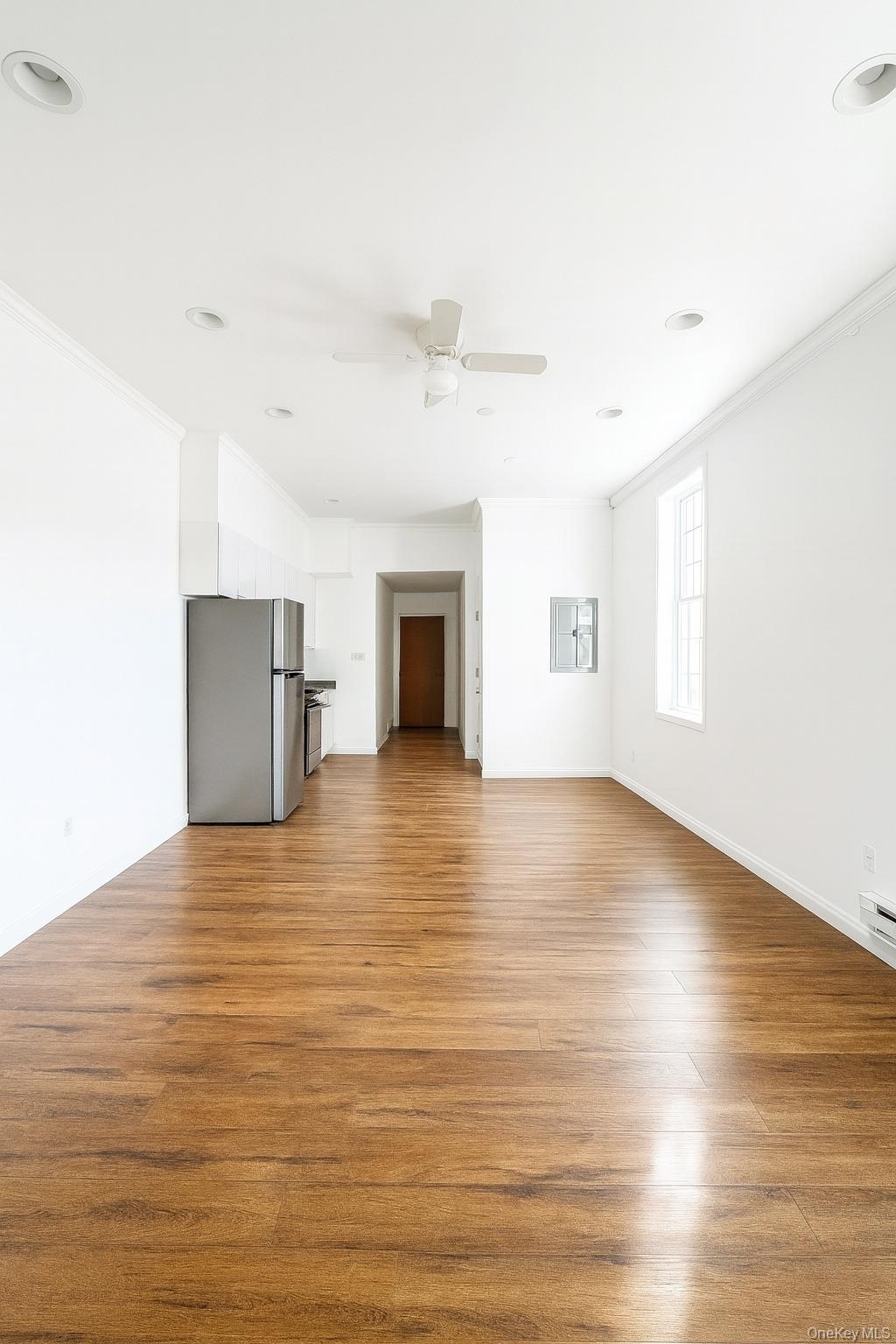 422 Broadway, Unit 5 Monticello, NY 12701 - Photo 2 of 9 an empty room with wooden floor and windows