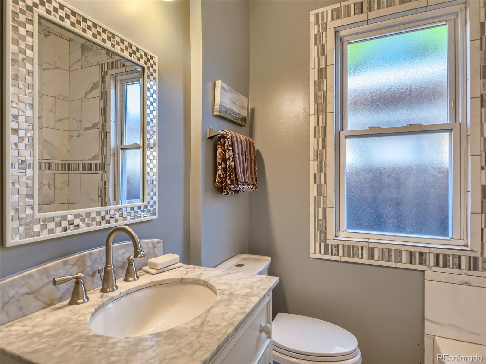 2958 Hooker Street Denver, CO 80211 - Photo 17 of 40 a bathroom with a sink toilet and mirror