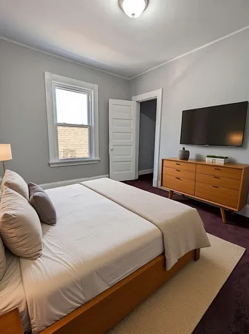 a bedroom with a bed and flat screen tv