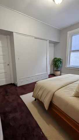 a bedroom with a bed and window