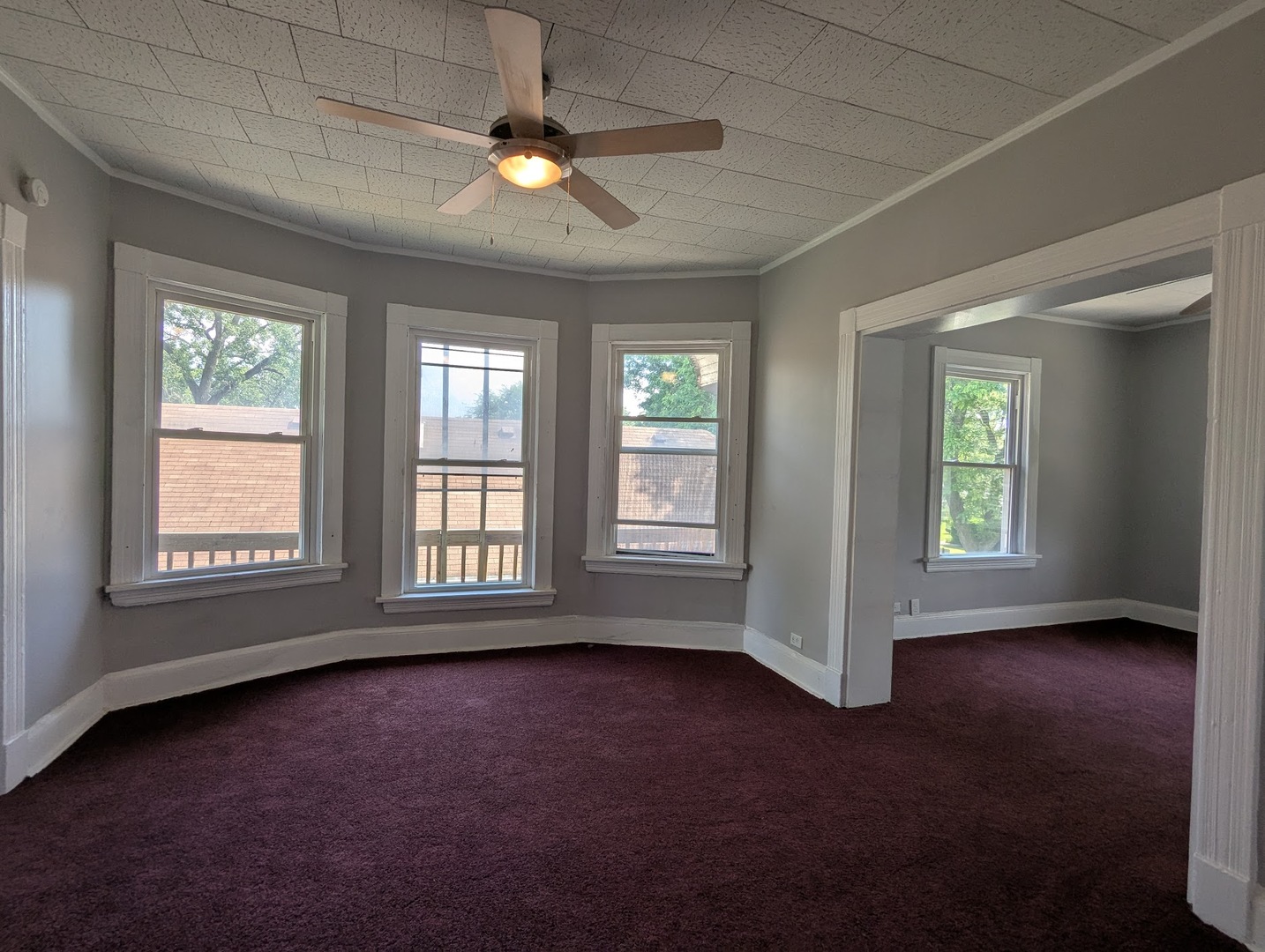 8817 South Elizabeth Street Chicago, IL 60620 - Photo 6 of 17 an empty room with chandelier fan and windows
