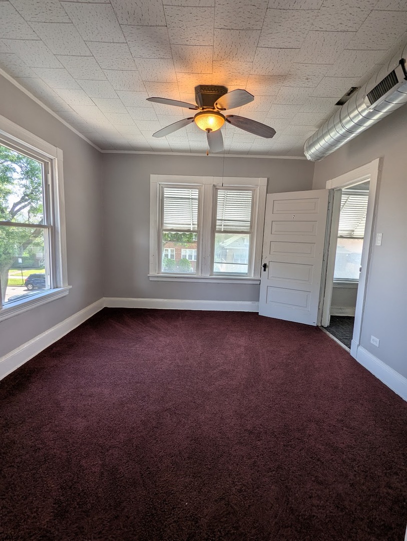 8817 South Elizabeth Street Chicago, IL 60620 - Photo 8 of 17 an empty room with a window and a ceiling fan