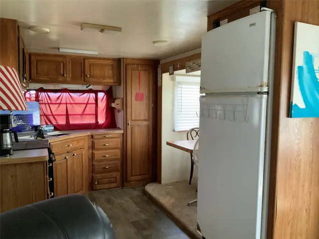 a kitchen with windows and refrigerator