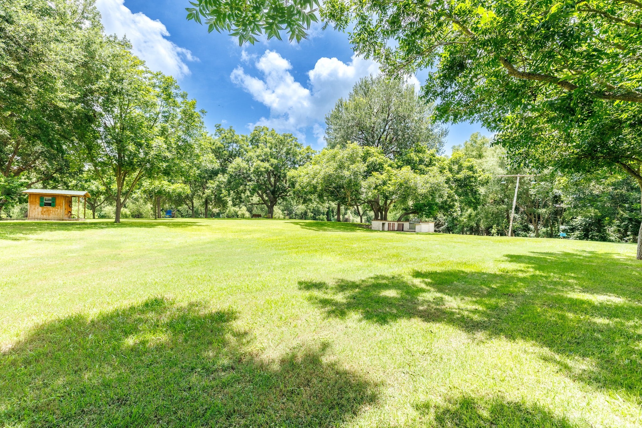 Tbd Goodwin Road Gonzales, TX 78629 - Photo 22 of 33 A spacious, verdant lawn invites outdoor activities under a clear sky and ample tree shade.