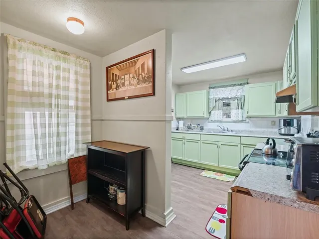 a kitchen with a sink cabinets and wooden floor