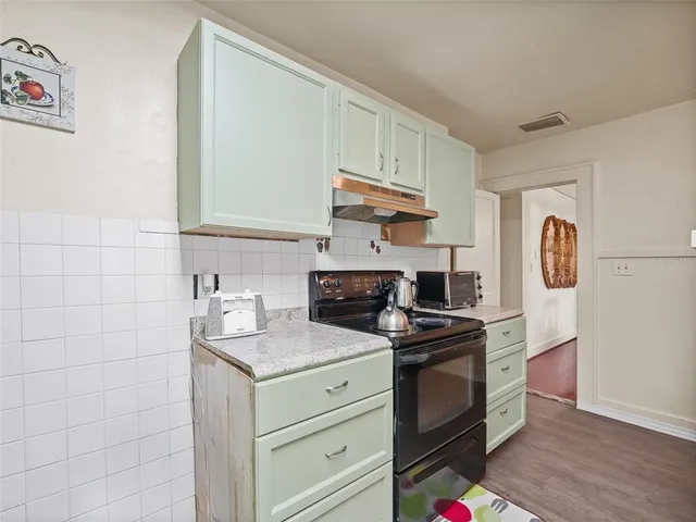 a kitchen with a stove cabinets and a refrigerator