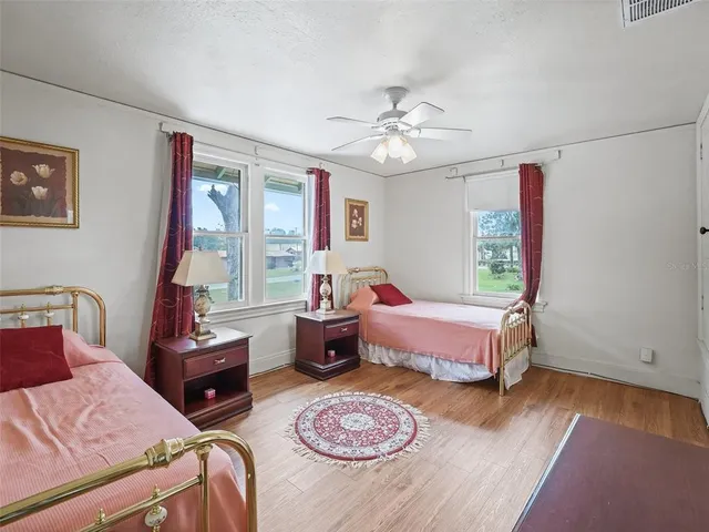 a bedroom with bed and wooden floor