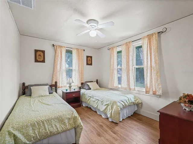 a bedroom with two beds and windows