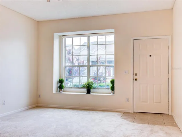 an empty room with a ceiling fan and carpet