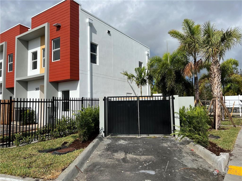 309 Foster Road, Unit 7 Hallandale Beach, FL 33009 - Photo 11 of 53 a front view of a house with a yard and garage