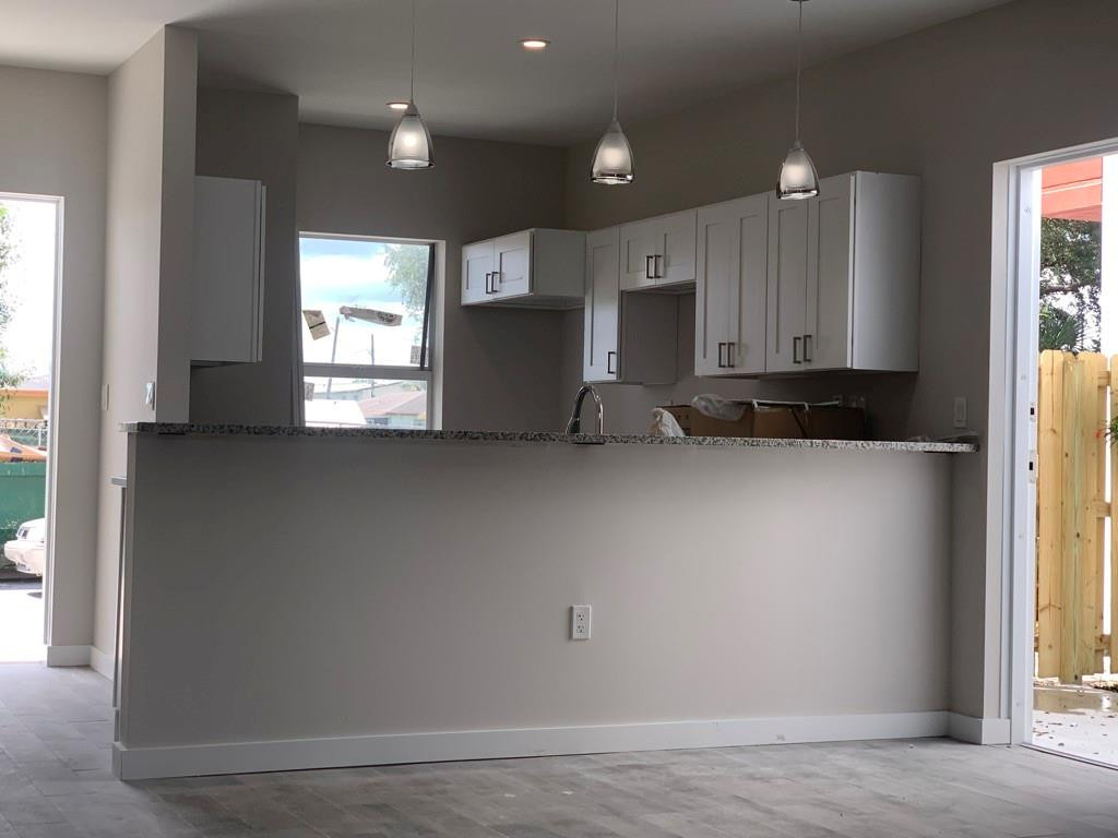 309 Foster Road, Unit 7 Hallandale Beach, FL 33009 - Photo 16 of 53 an empty room with wooden floor and windows