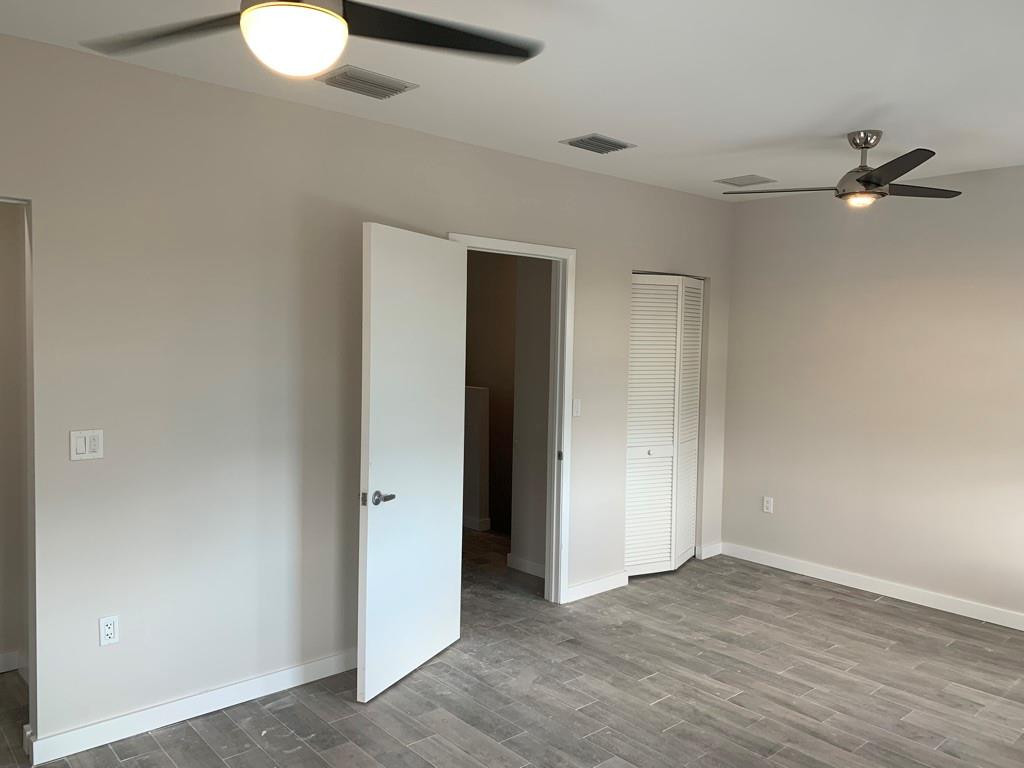 309 Foster Road, Unit 7 Hallandale Beach, FL 33009 - Photo 31 of 53 an empty room with wooden floor and windows