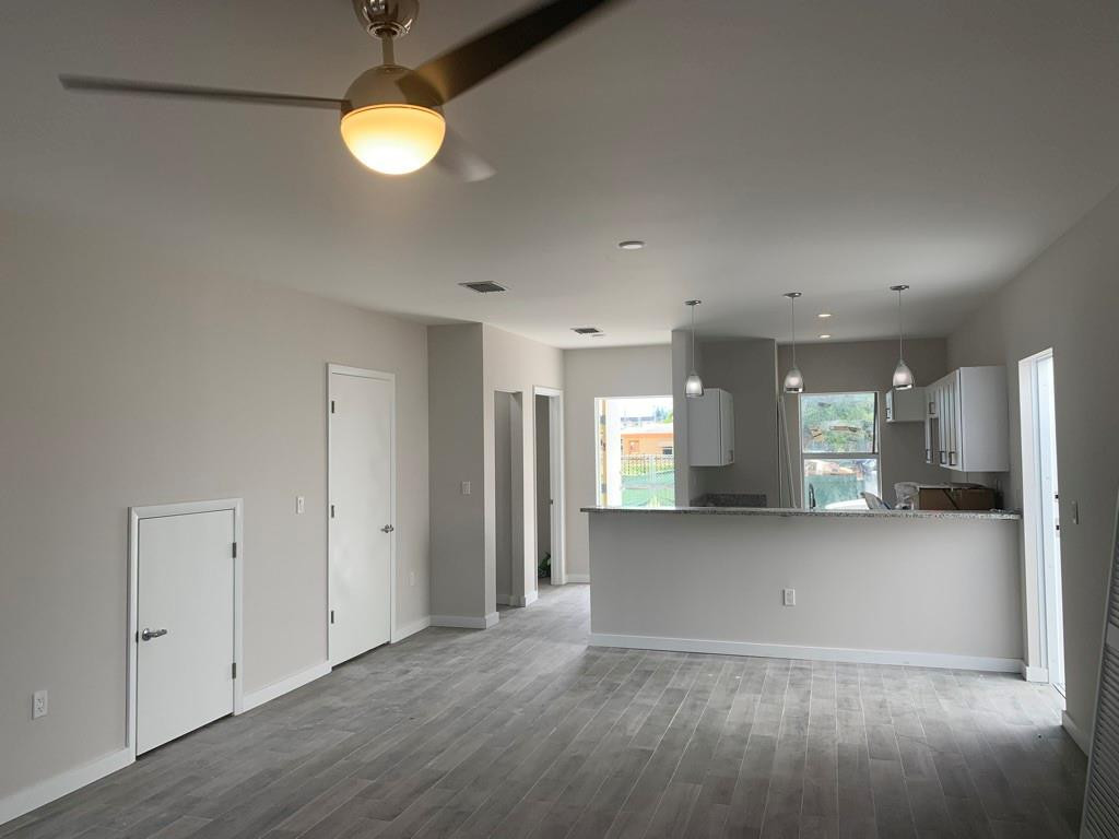 309 Foster Road, Unit 7 Hallandale Beach, FL 33009 - Photo 36 of 53 an empty room with wooden floor and windows
