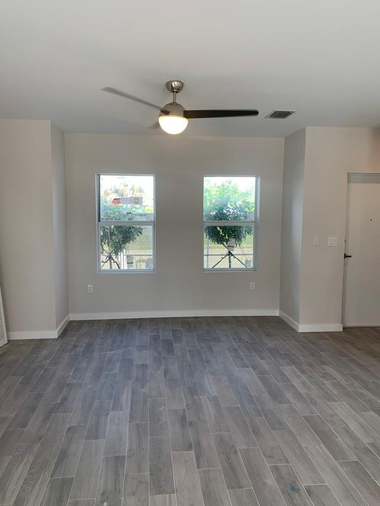 309 Foster Road, Unit 7 Hallandale Beach, FL 33009 - Photo 39 of 53 an empty room with wooden floor and windows