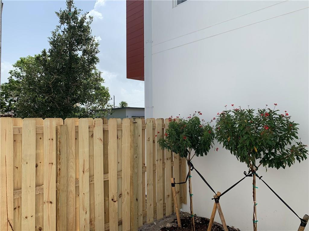 309 Foster Road, Unit 7 Hallandale Beach, FL 33009 - Photo 50 of 53 a street view with wooden fence and trees