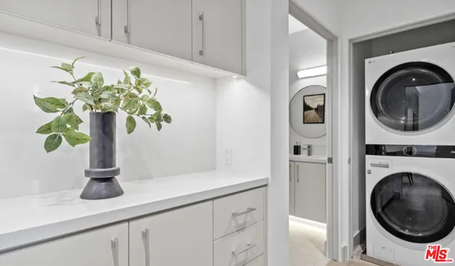 a white vase with white and yellow flowers