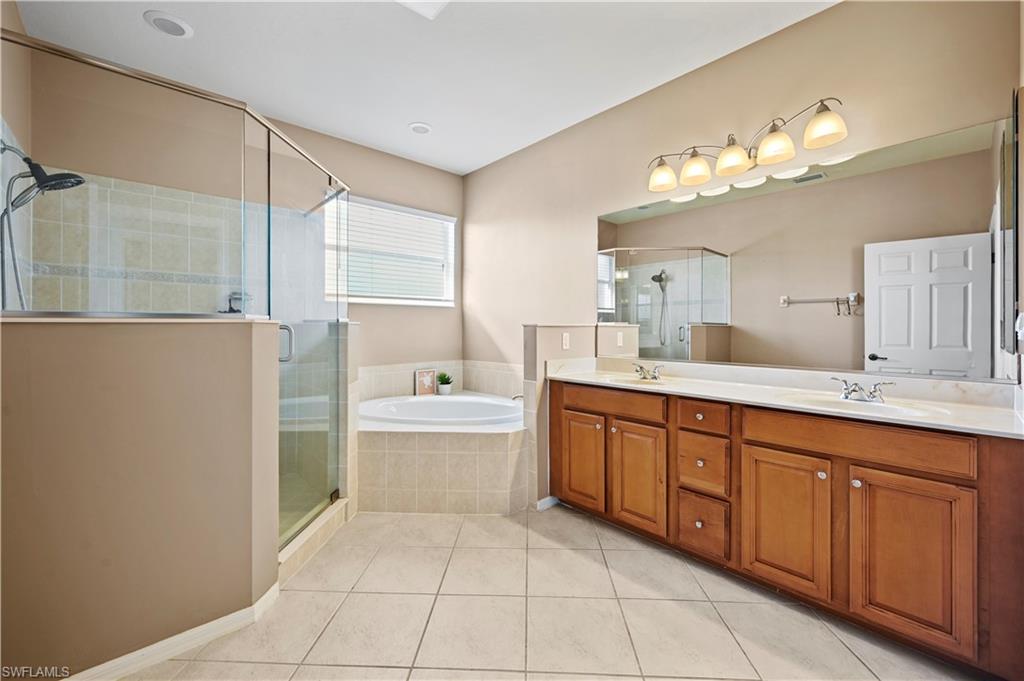 20686 Larino Loop Estero, FL 33928 - Photo 20 of 47 a spacious bathroom with a granite countertop sink a mirror and a bathtub