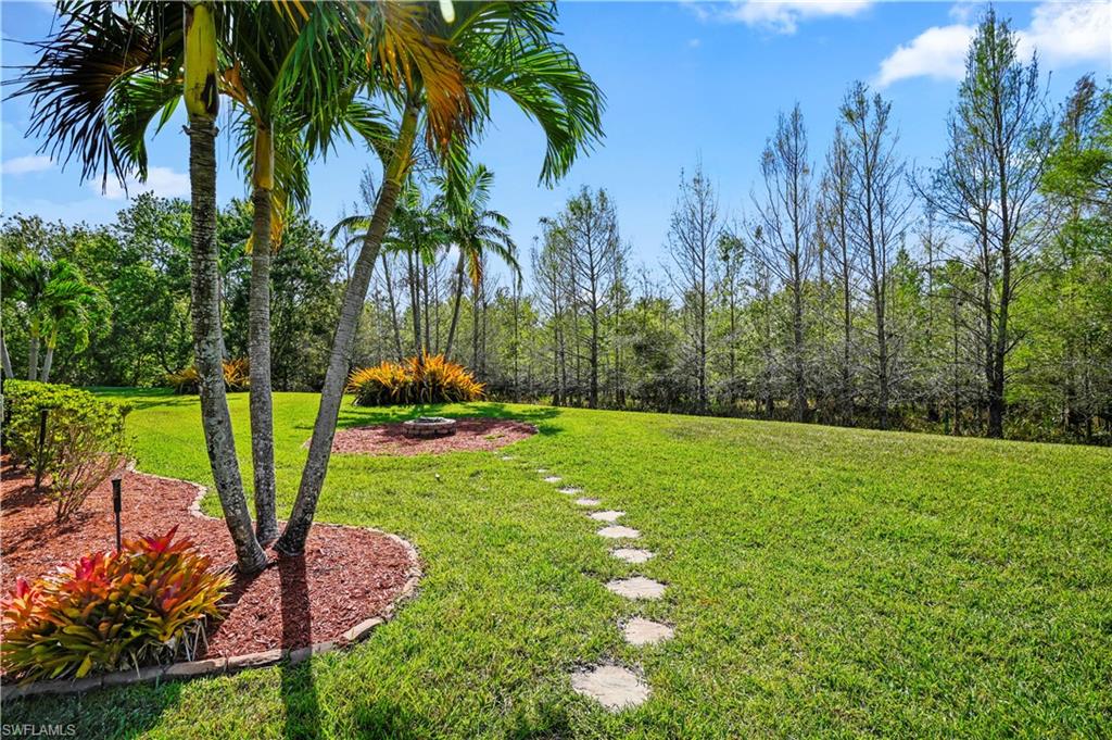 20686 Larino Loop Estero, FL 33928 - Photo 28 of 47 a backyard of a house with table and chairs potted plants and large trees