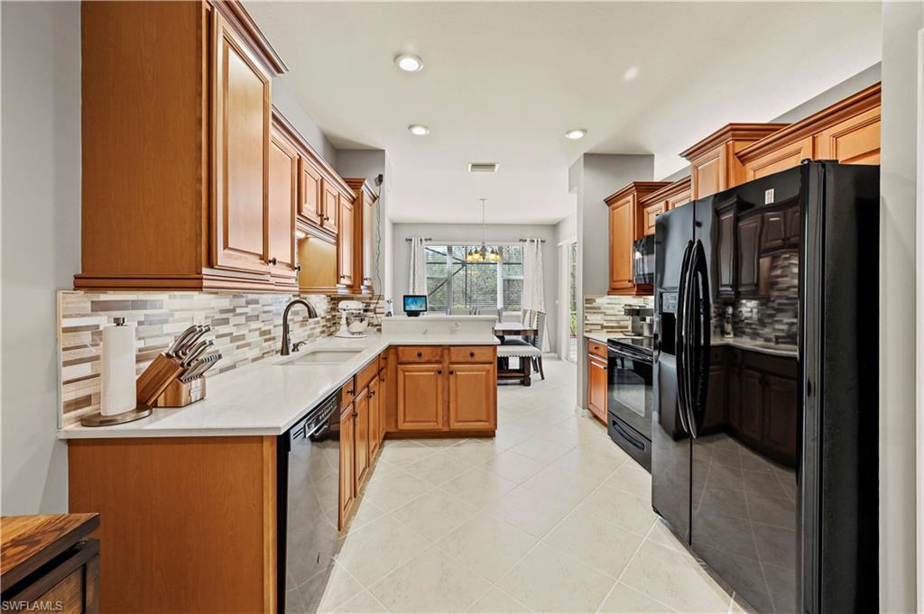 20686 Larino Loop Estero, FL 33928 - Photo 5 of 47 a kitchen with stainless steel appliances granite countertop a sink a stove and a refrigerator