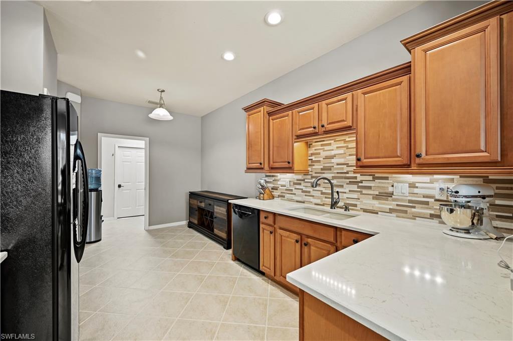 20686 Larino Loop Estero, FL 33928 - Photo 7 of 47 a kitchen with stainless steel appliances granite countertop a sink stove and refrigerator