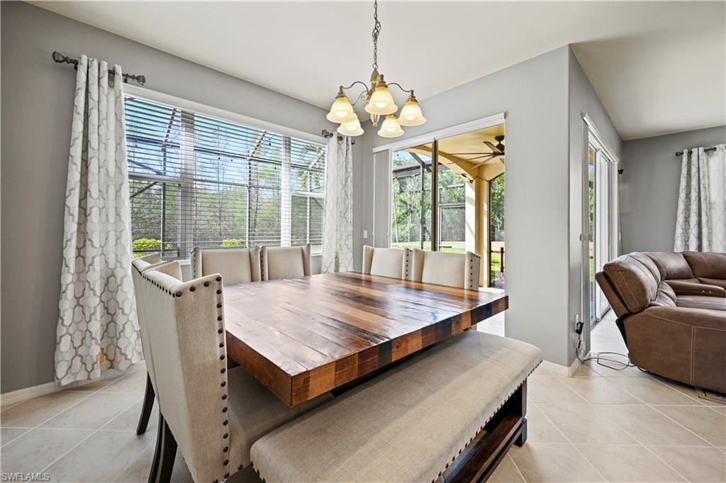 20686 Larino Loop Estero, FL 33928 - Photo 9 of 47 a dining room with wooden floor a chandelier a wooden table and chairs