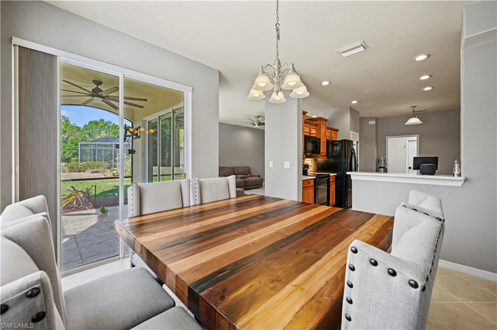 20686 Larino Loop Estero, FL 33928 - Photo 10 of 47 a open kitchen with kitchen island a large window cabinets a sink and stainless steel appliances