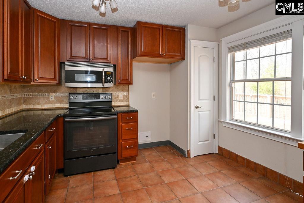 88 Running Deer Road Blythewood, SC 29016 - Photo 7 of 24 a kitchen with granite countertop a refrigerator and a stove top oven