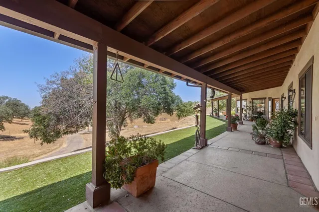 a patio with glass top table and chairs