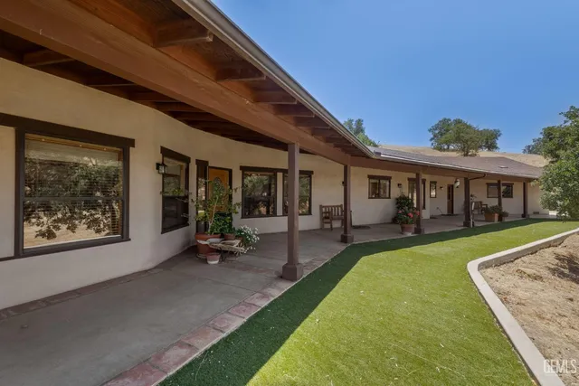 a view of a house with backyard and sitting area