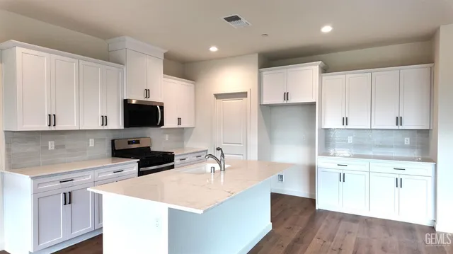 a kitchen with white cabinets sink and stainless steel appliances