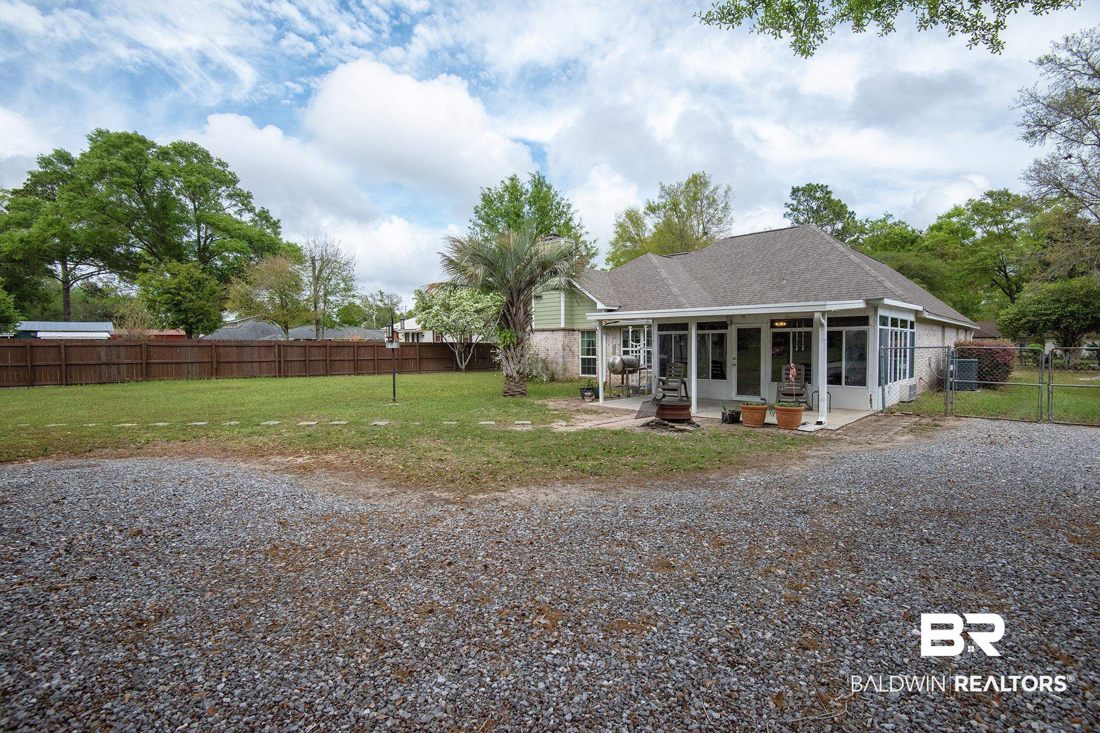 10093 Willis Road Foley, AL 36535 - Photo 27 of 33 Rear view of property with a fenced backyard, a shingled roof, a sunroom, a gate, and a patio