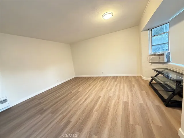 a view of a room with wooden floor and electronic appliances