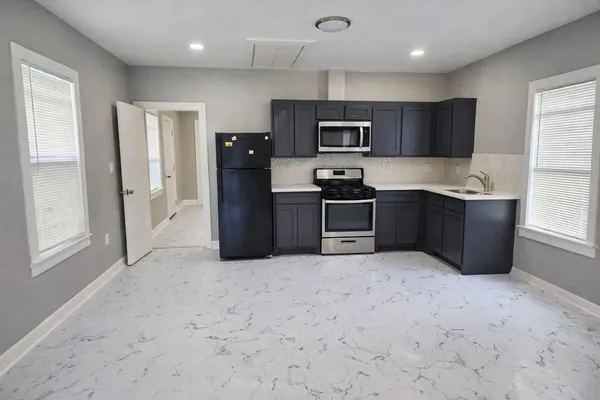 a large kitchen with cabinets and stainless steel appliances